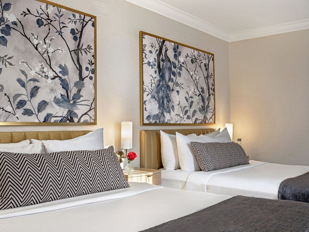 Two queen beds with white linens and blue and black patterned pillows at Warwick Allerton Chicago