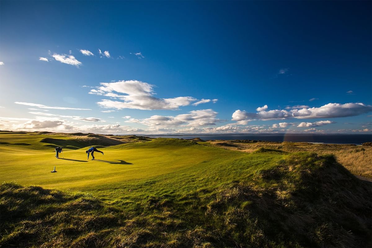 Golfers on a sunny coastal golf course at Seaton House