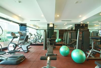 Interior view of the gym with exercise equipment at Amora Neoluxe Hotel Bangkok