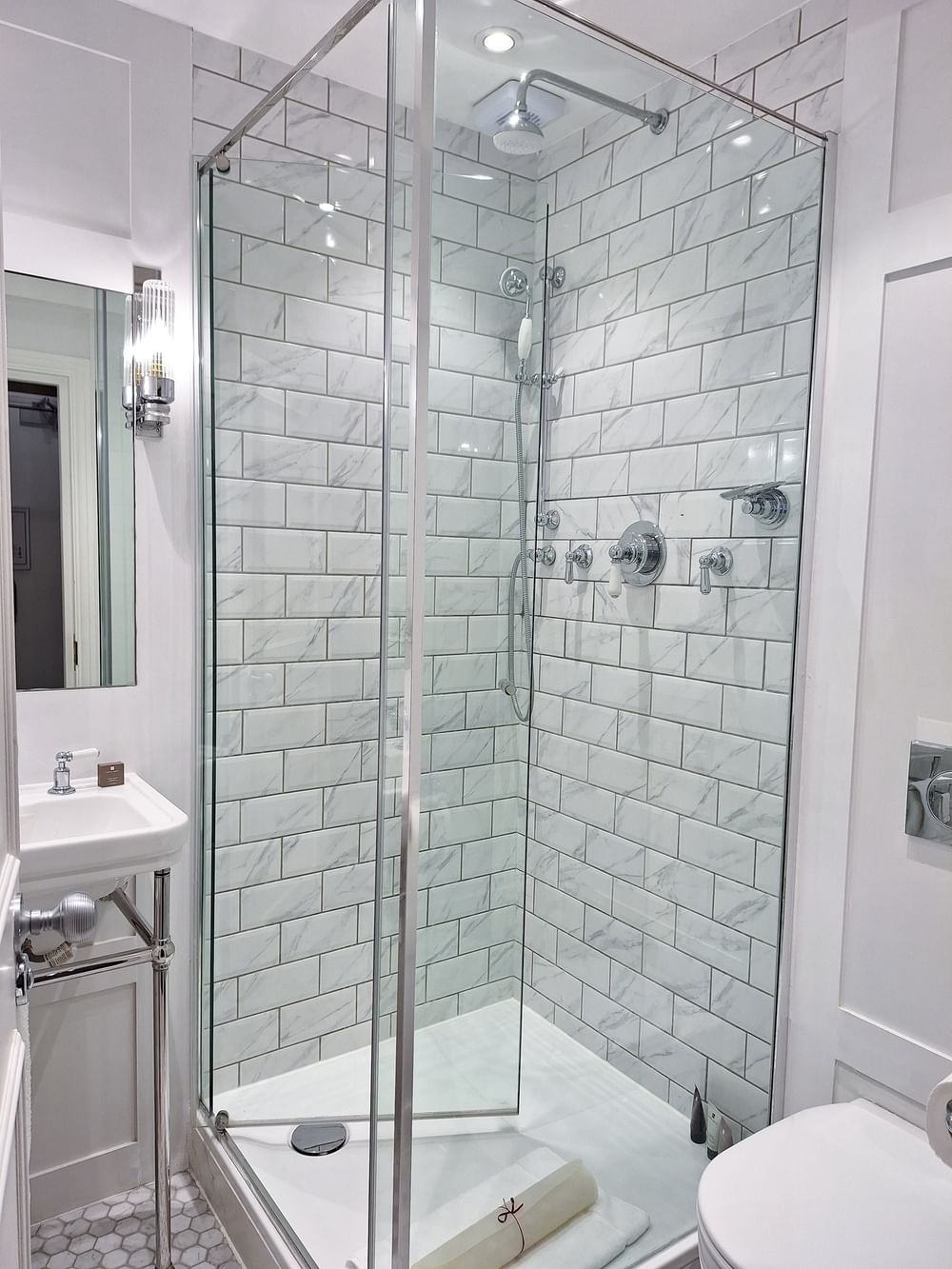 Modern bathroom with a glass shower enclosure and white tiles at The Capital Hotel, Apartments & Townhouse