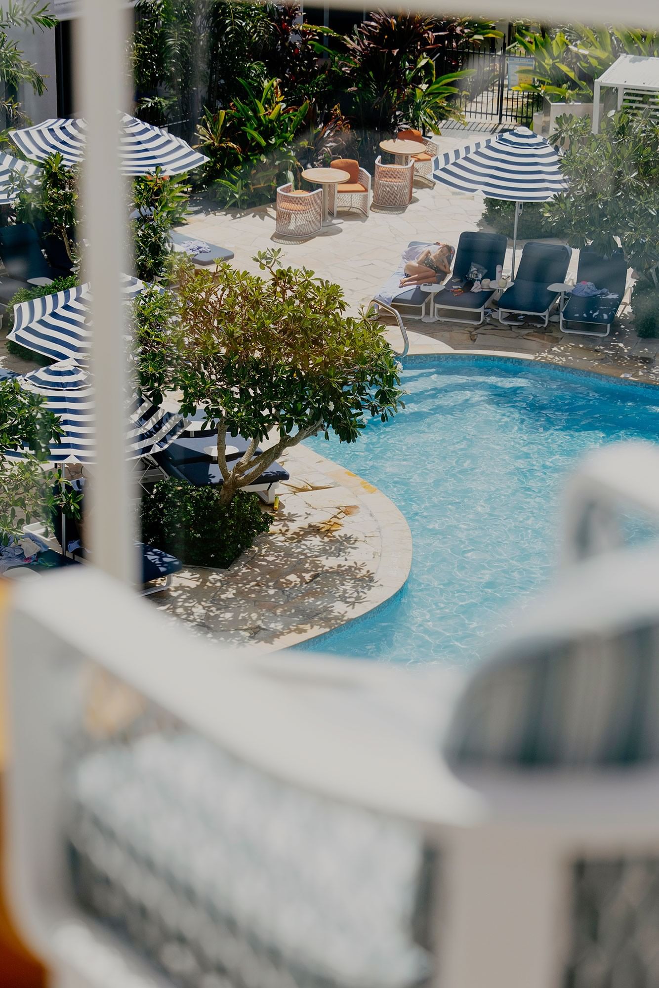 Outdoor pool with lounge chairs and umbrellas at Elysium Hotels