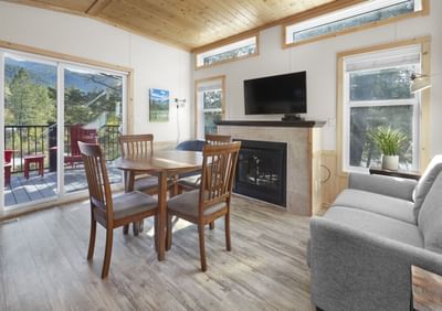 Mountain View Cabin with dining table, sofa and a TV at Fairmont Hot Springs Resort
