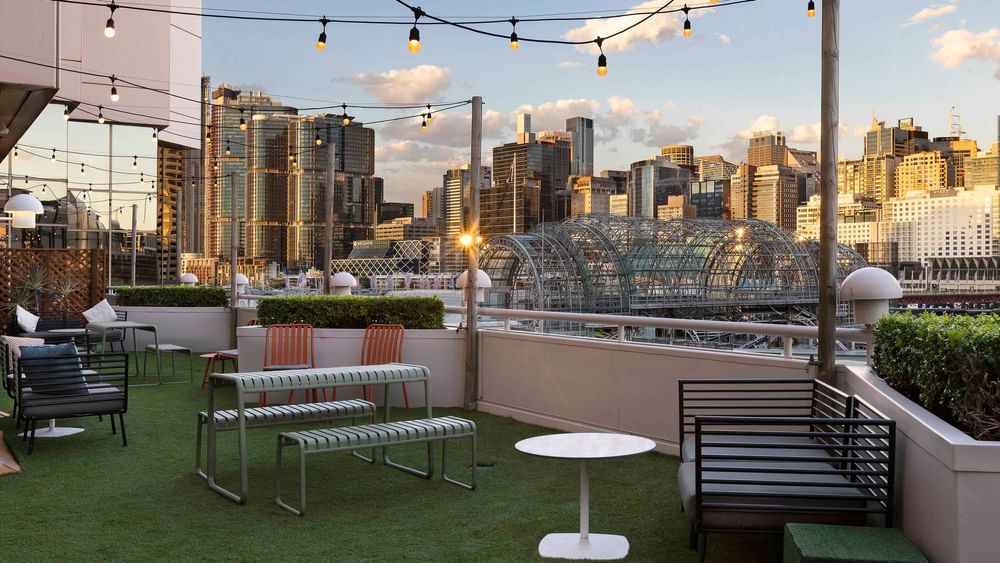 Rooftop terrace of The Barossa Room with city skyline views and festive string lights at Novotel Sydney on Darling Harbour
