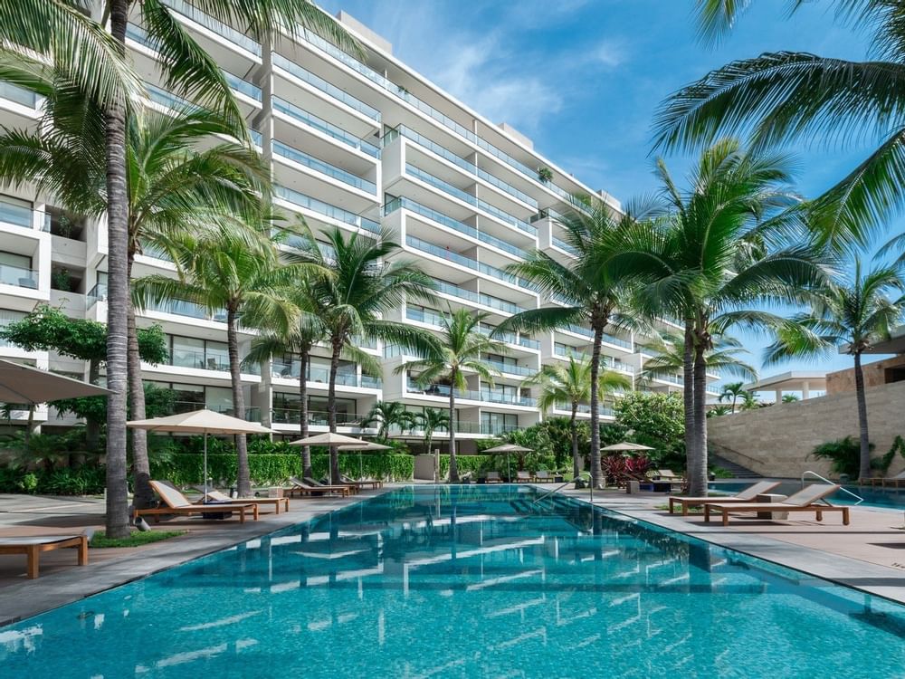 Pool with sun loungers at Live Aqua Private Residences