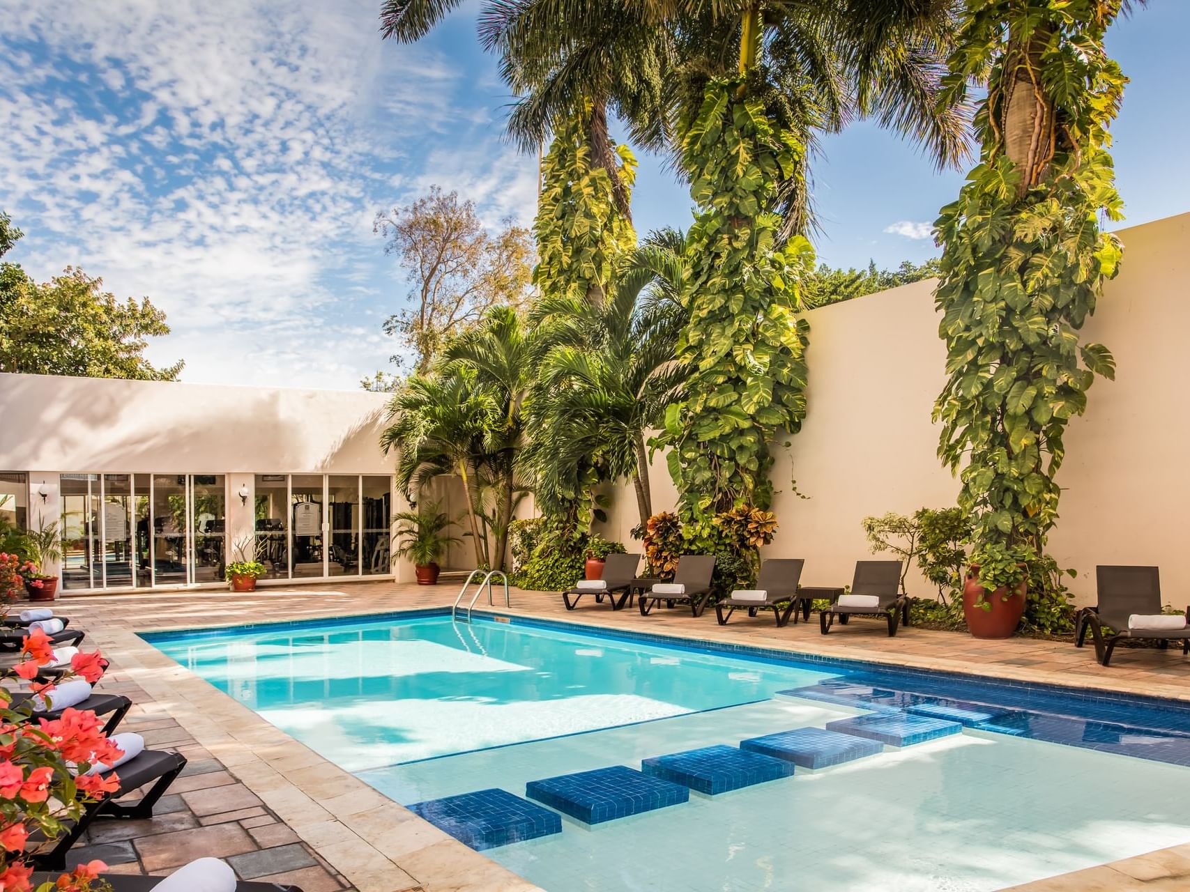 Modern swimming pool, sunbeds & plants at Gamma Hotels