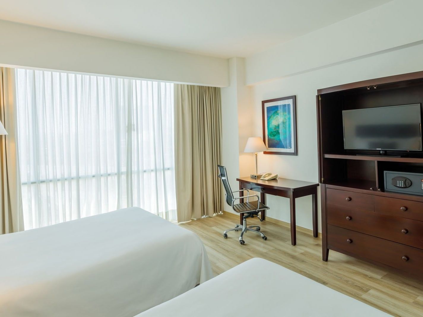 2 Double Camino Real Club including a dark wood media console, a desk, and soft natural lighting at Camino Real Pachuca