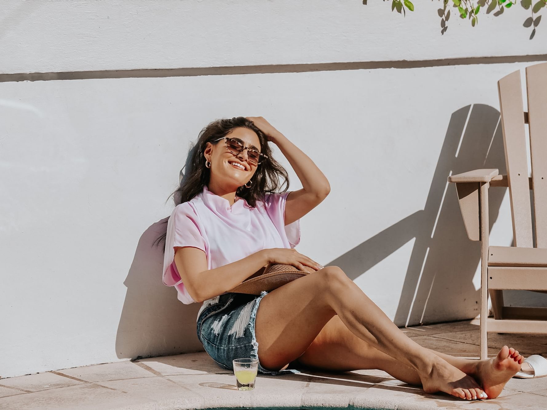 Closeup of a girl sitting by a wall near a pool at Crest Hotel