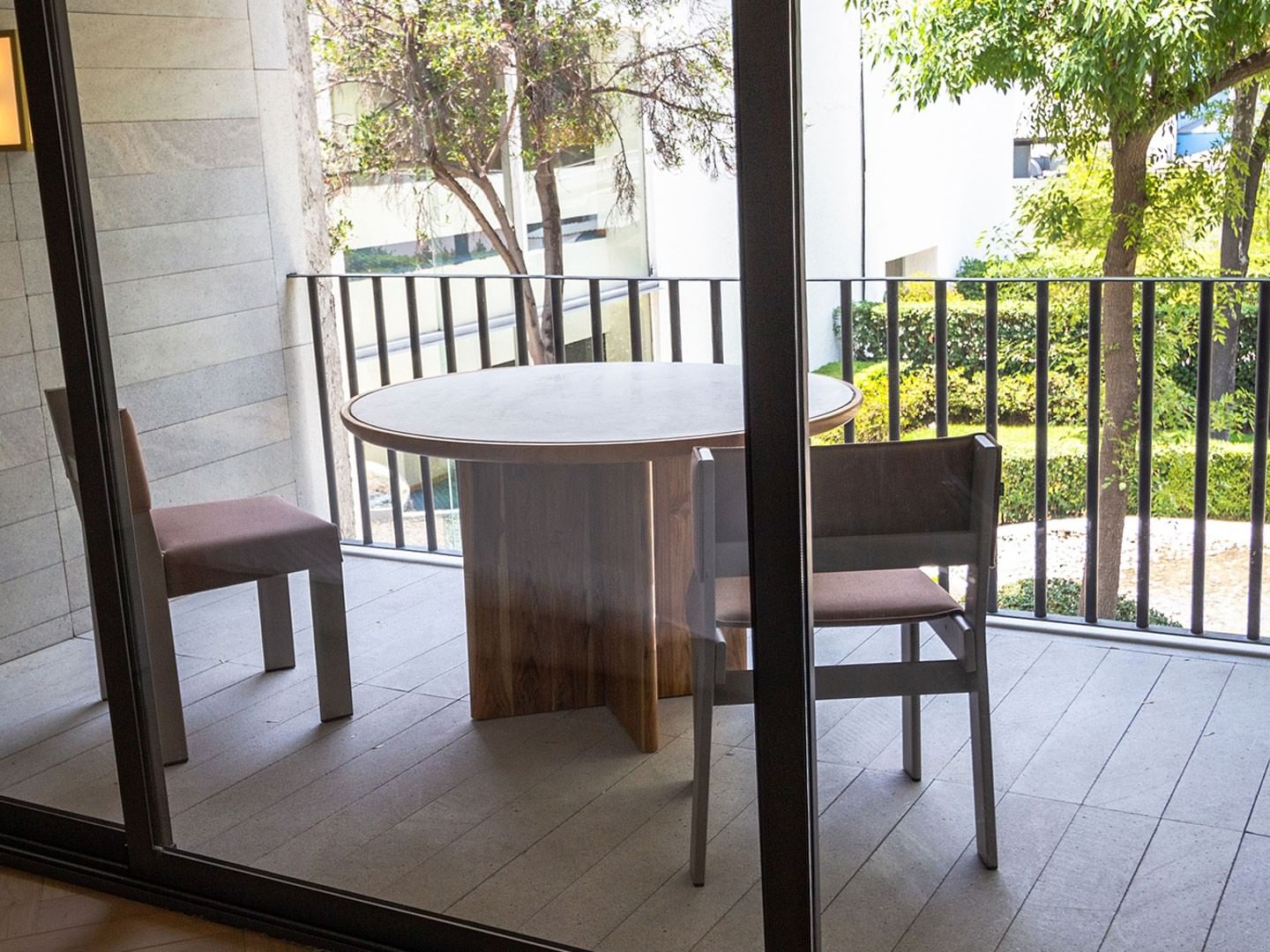 King Superior Viceroys Suite balcony with a table and chairs overlooking lush green trees at Camino Real Polanco Mexico