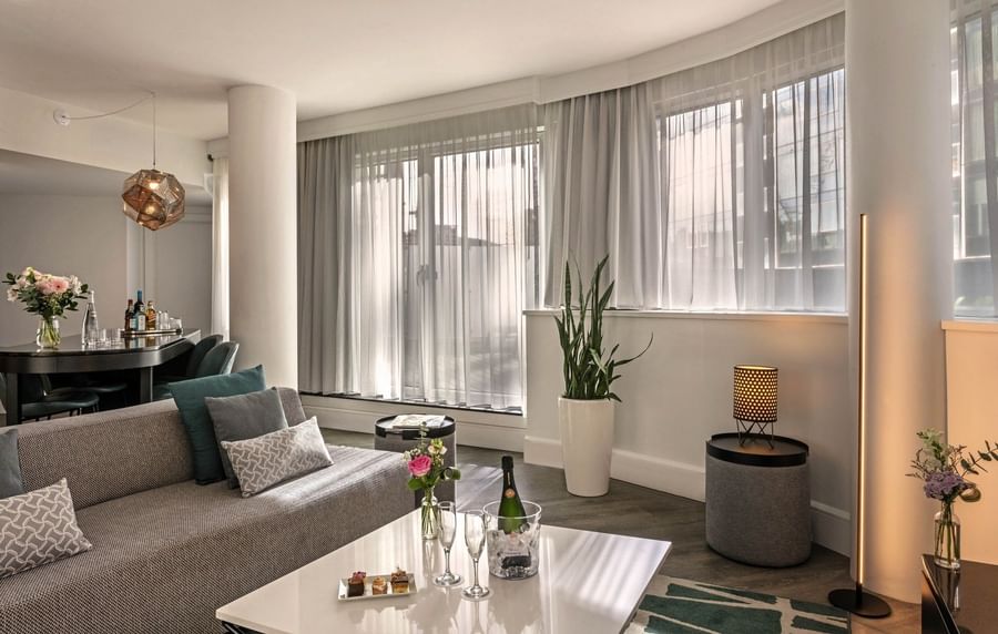 Plush sofa with coffee table near window in Penthouse Drummond at Warwick Le Crystal Montreal