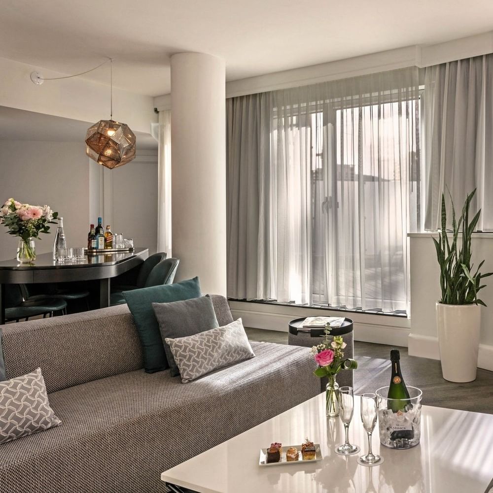 Plush sofa with coffee table near window in Penthouse Drummond at Warwick Le Crystal Montreal