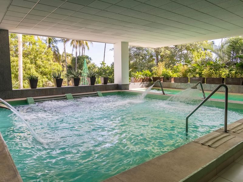 Piscina con chorros de agua y vegetación en el exterior del Fiesta Americana Riviera Nayarit Resort & Spa