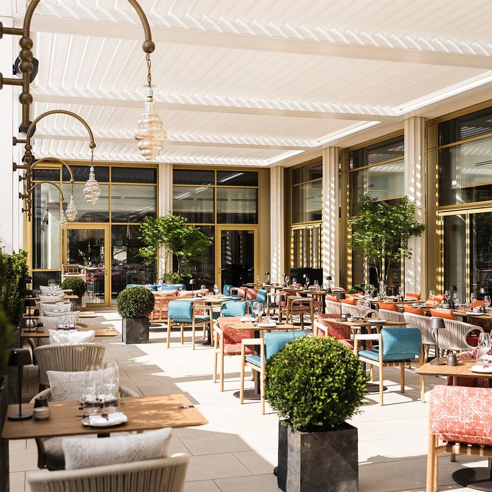 Ein stilvolles Restaurant mit modernen Möbeln, großen Fenstern und eleganten Beleuchtungskörpern.