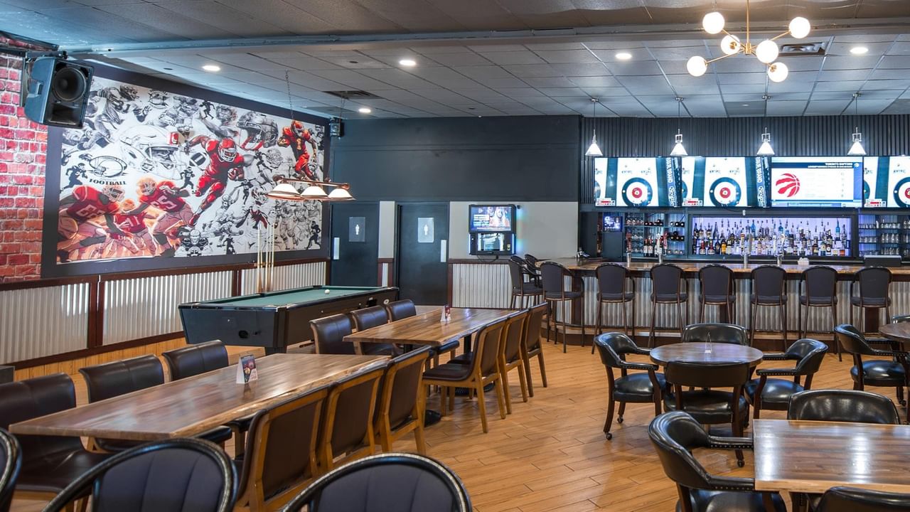Bar area with pool table and sports mural.