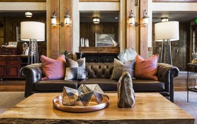 Cozy lounge featuring a dark leather couch with a wooden coffee table by a stylish lamps at Hotel Park City Autograph Collection 