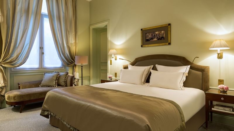 Large bed with warm lighting in Deluxe Parisian suite at Hôtel Westminster - Paris