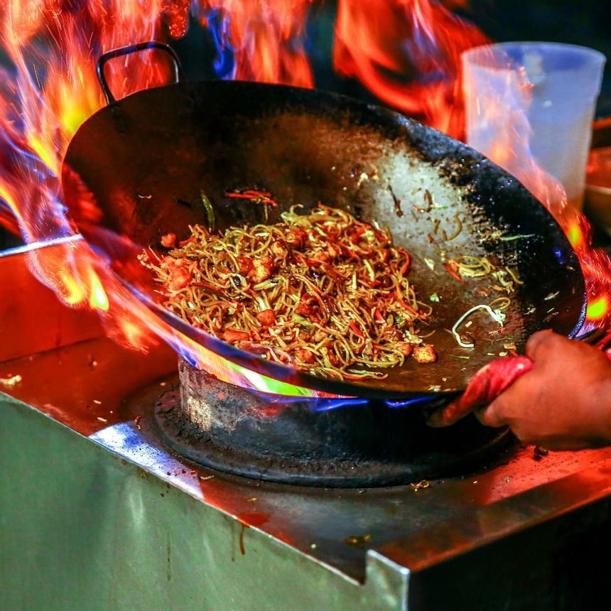 Noodles in wok with flames