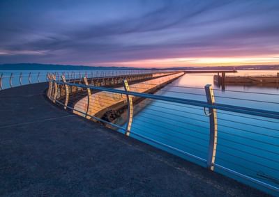 Golden hour view of the Victoria Inner Harbour walkway and marina, with the city skyline, close to Embassy Inn Victoria