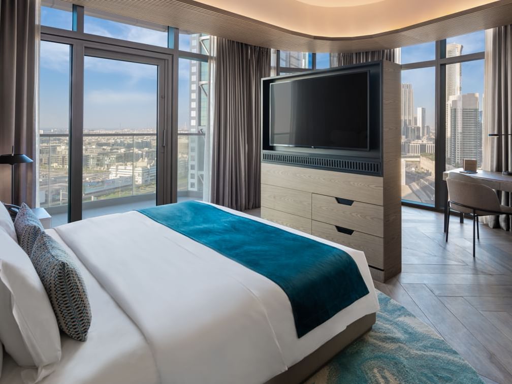 A large TV facing a comfy bed in Paramount Suite at Paramount Hotel Midtown