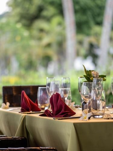 Dining table set with red napkins & wine glasses, and floral accents in Wild Ginger Restaurant at warwick le lagon-vanuatu