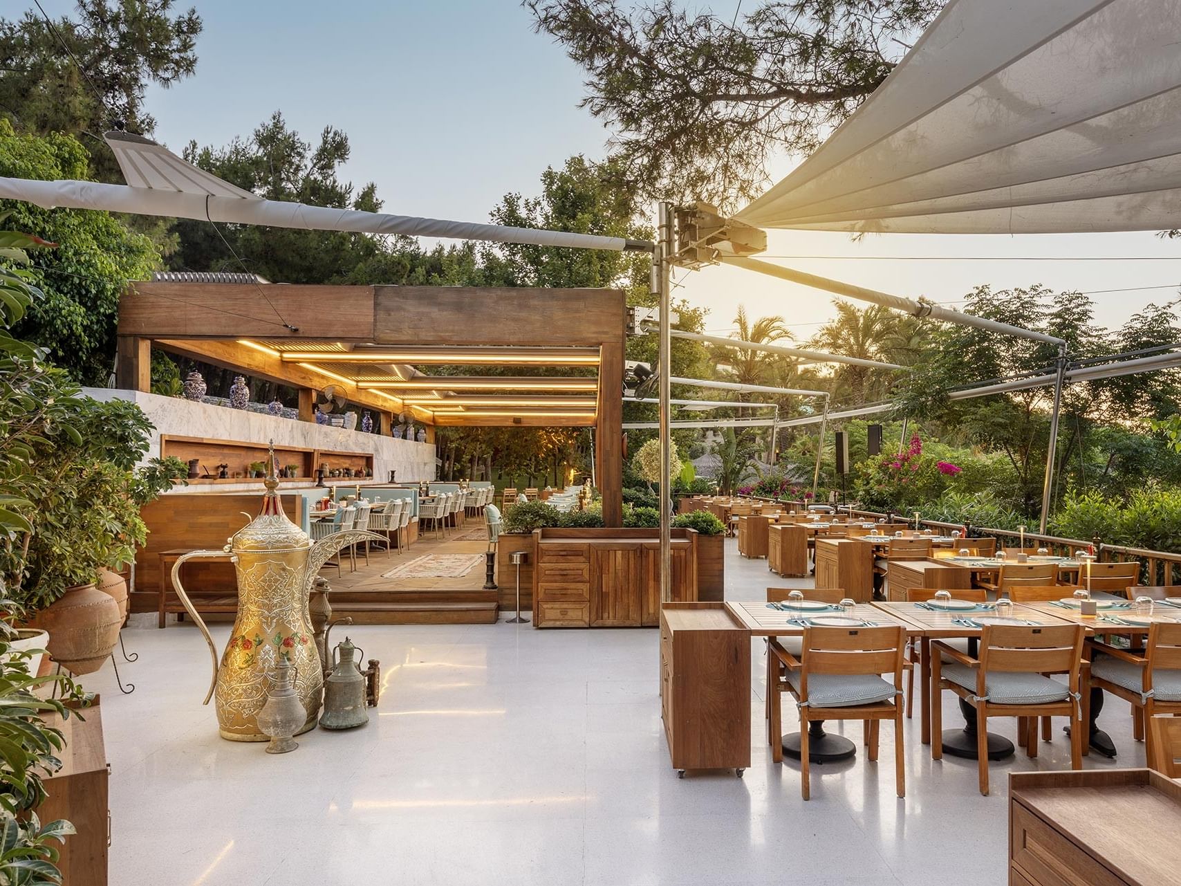 Stylish open-air terrace with tables, chairs, and décor at Titanic Luxury Collection Bodrum.
