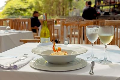 Plato de mariscos servido con vino en un restaurante al aire libre en el Hotel Dann Carlton Medellín