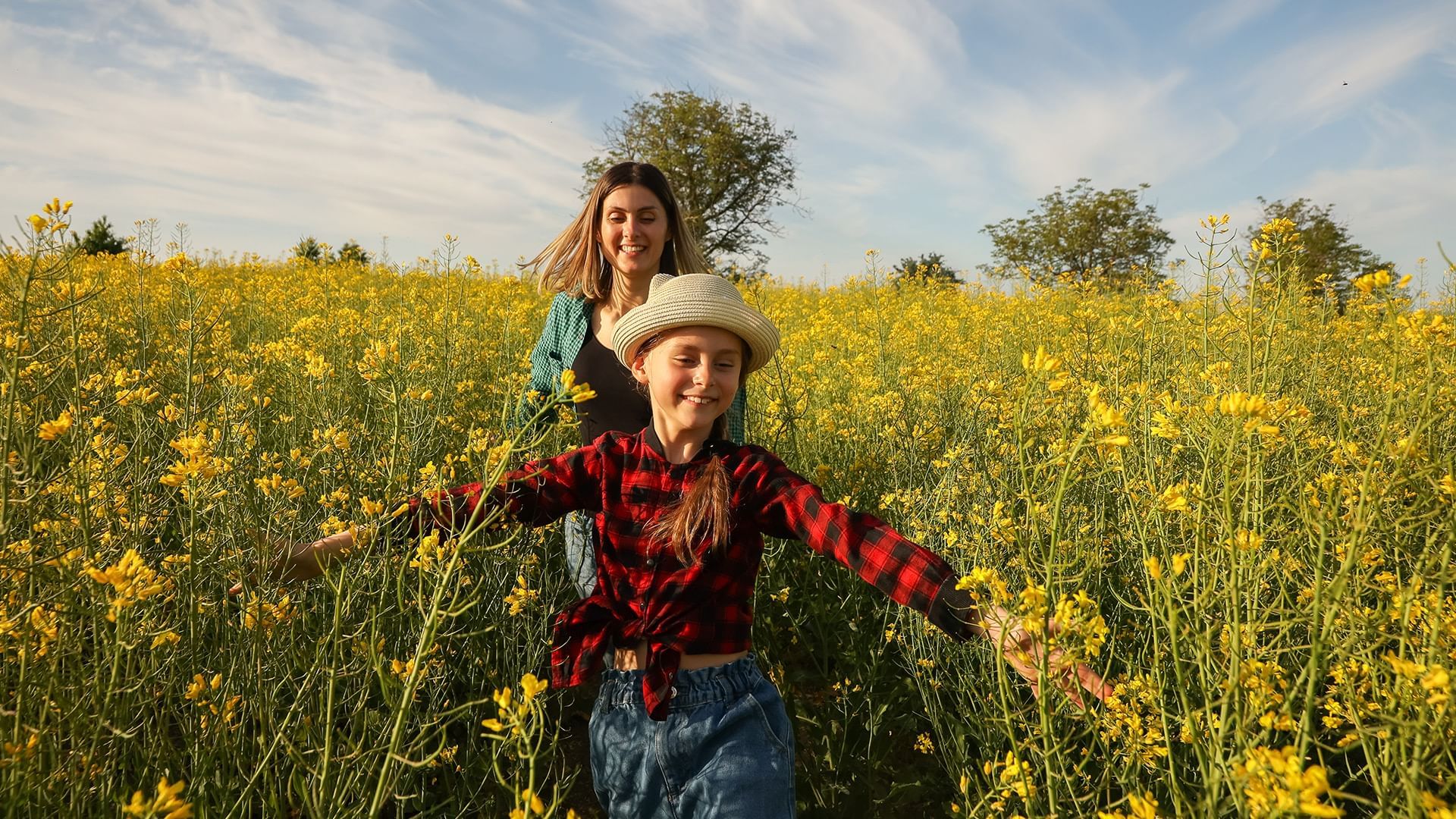 Mom and daughter running in a field