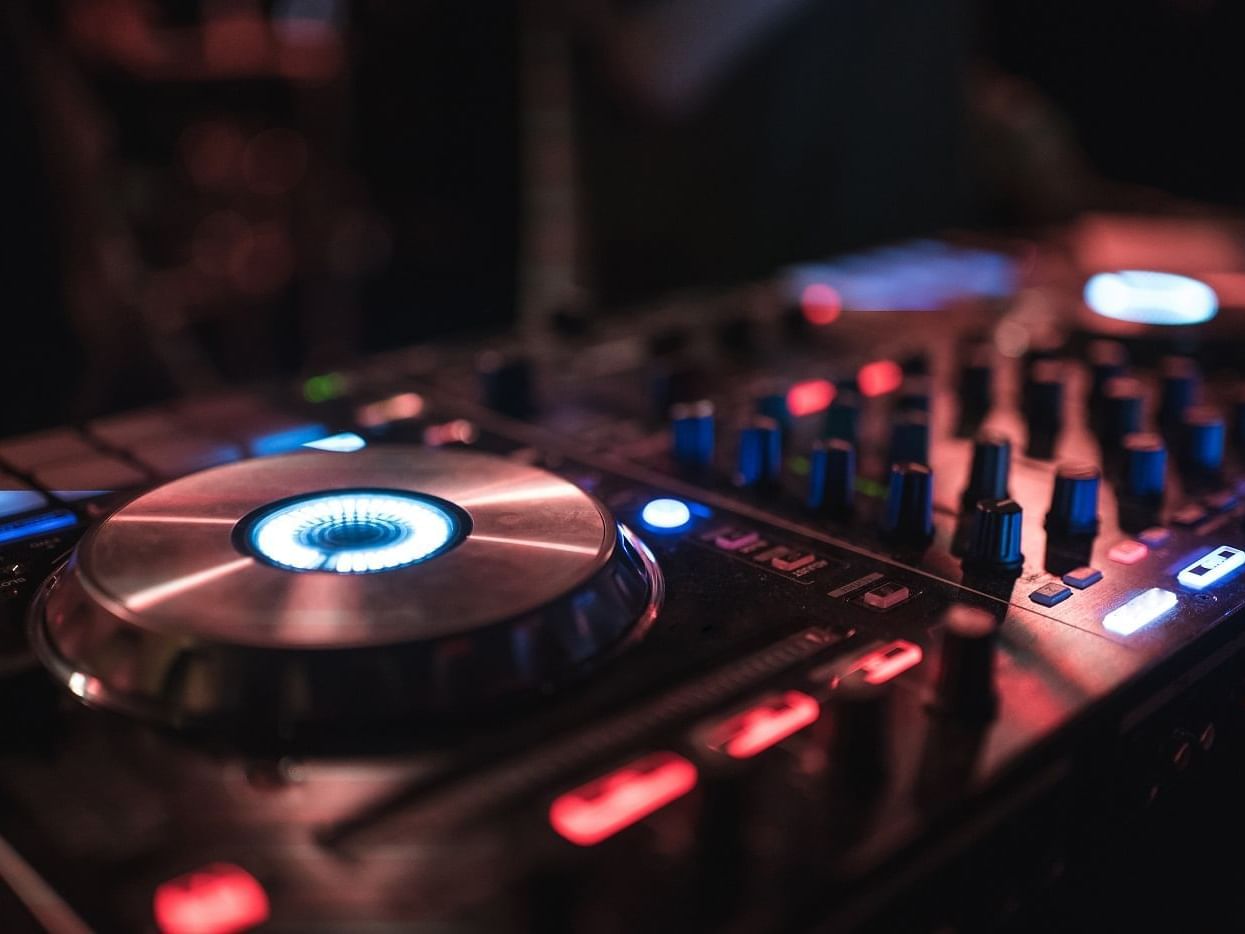 Close-up of a DJ mixer in a dimly lit environment at The Londoner Hotel