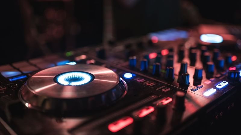 Close-up of a DJ mixer in a dimly lit environment at The Londoner Hotel