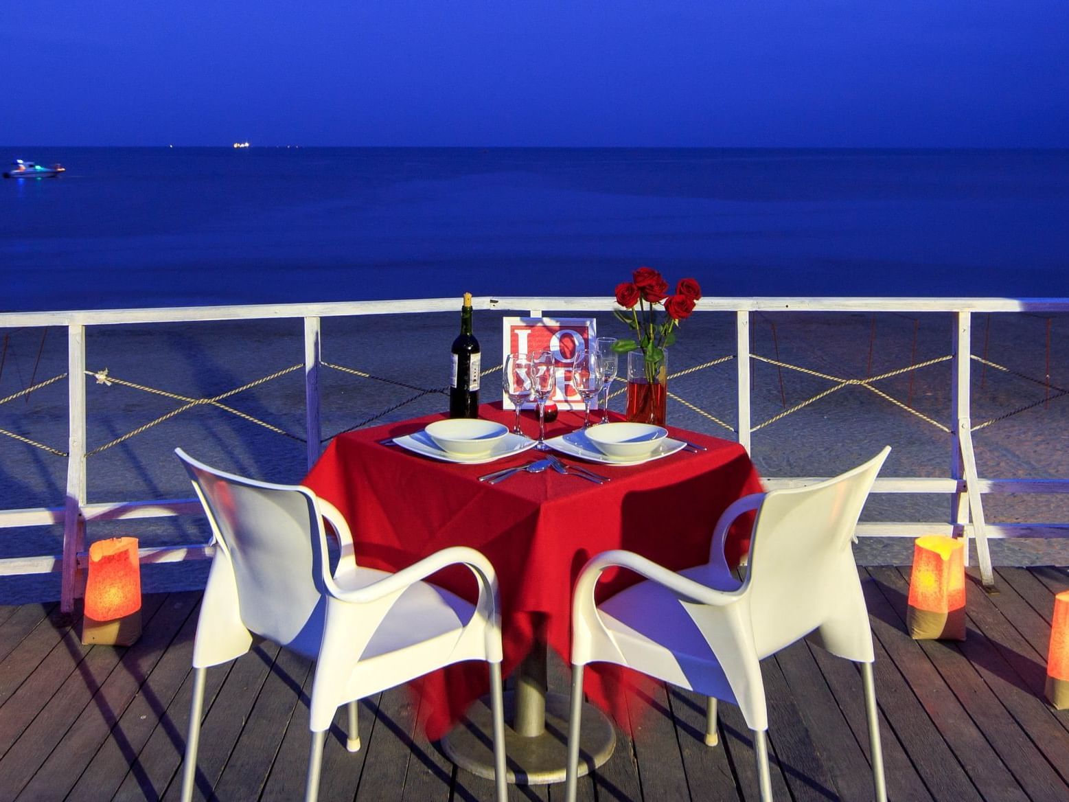 Romantic dinner setup on a platform by the beach at DOT Hotels