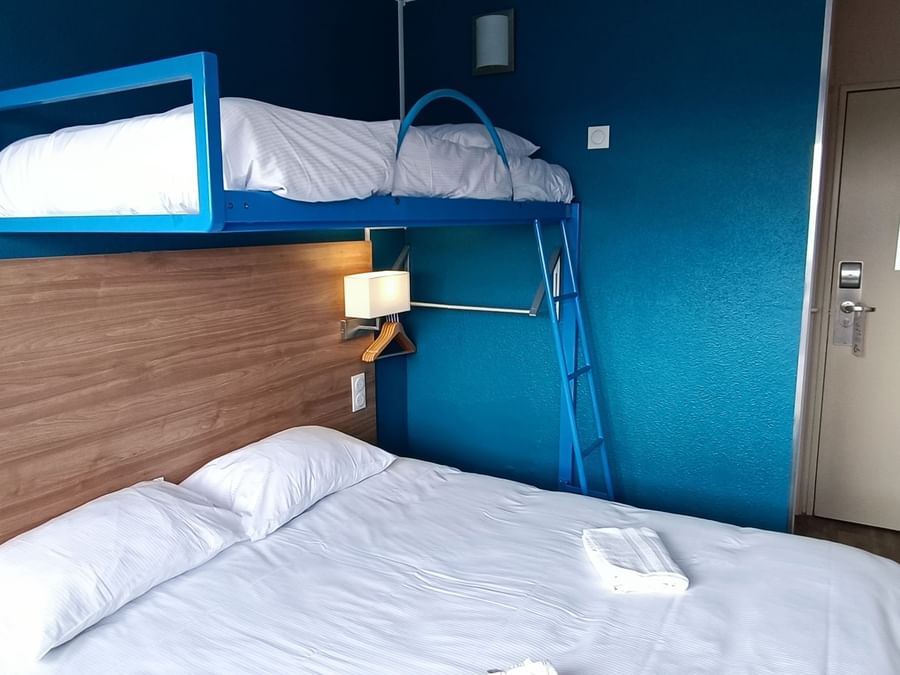 Double bed with a bunk bed in a room at The Originals Hotels
