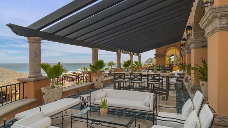 Bar Santo Al Reves with sofas and high-top seating under a pergola, overlooking the ocean at Hacienda Del Mar Los Cabos