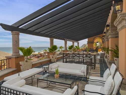 Bar Santo Al Reves with sofas and high-top seating under a pergola, overlooking the ocean at Hacienda Del Mar Los Cabos
