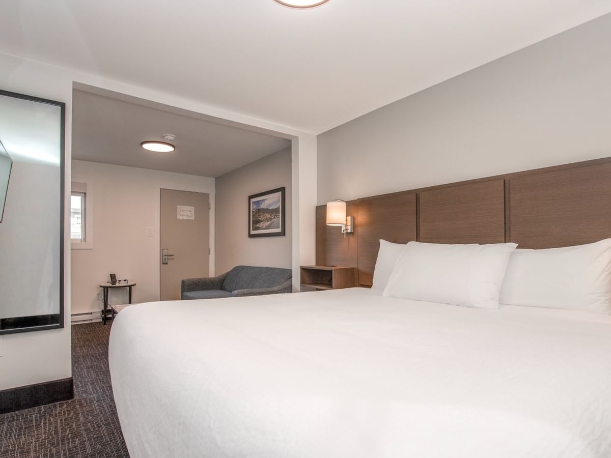 Modern hotel suite with a living area and king bed.