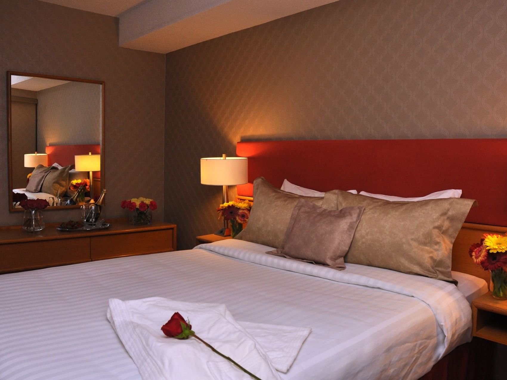 A rose on a bed in Superior Suite at Cartier Place Suite Hotel