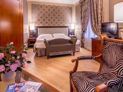 King bed, sofa, TV & chairs in Junior Suite at Grand Visconti Palace