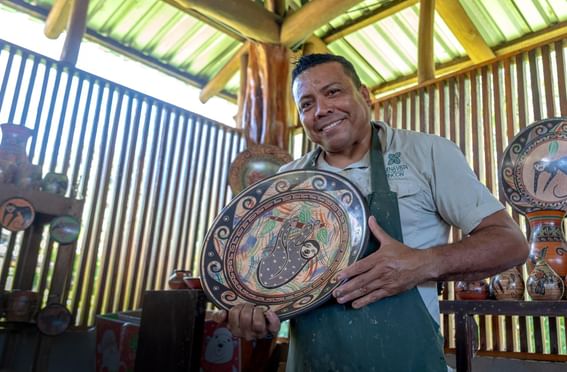 A man posing with a ceramic plate at Buena Vista Del Rincon