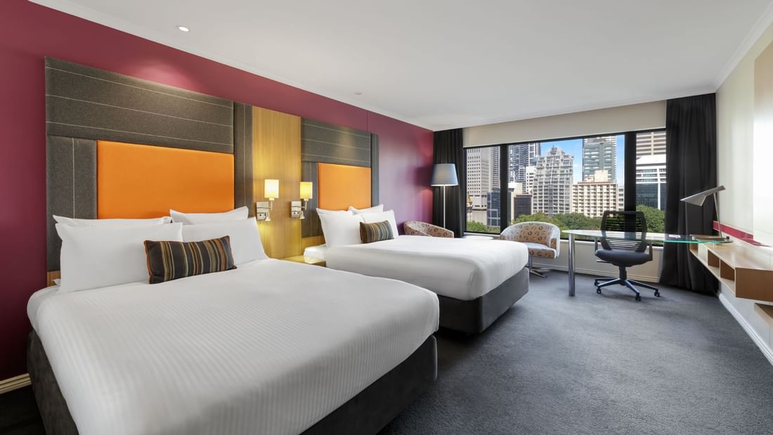 Comfy beds & lounge overlooking the city in Superior Room at Pullman Sydney Hyde Park