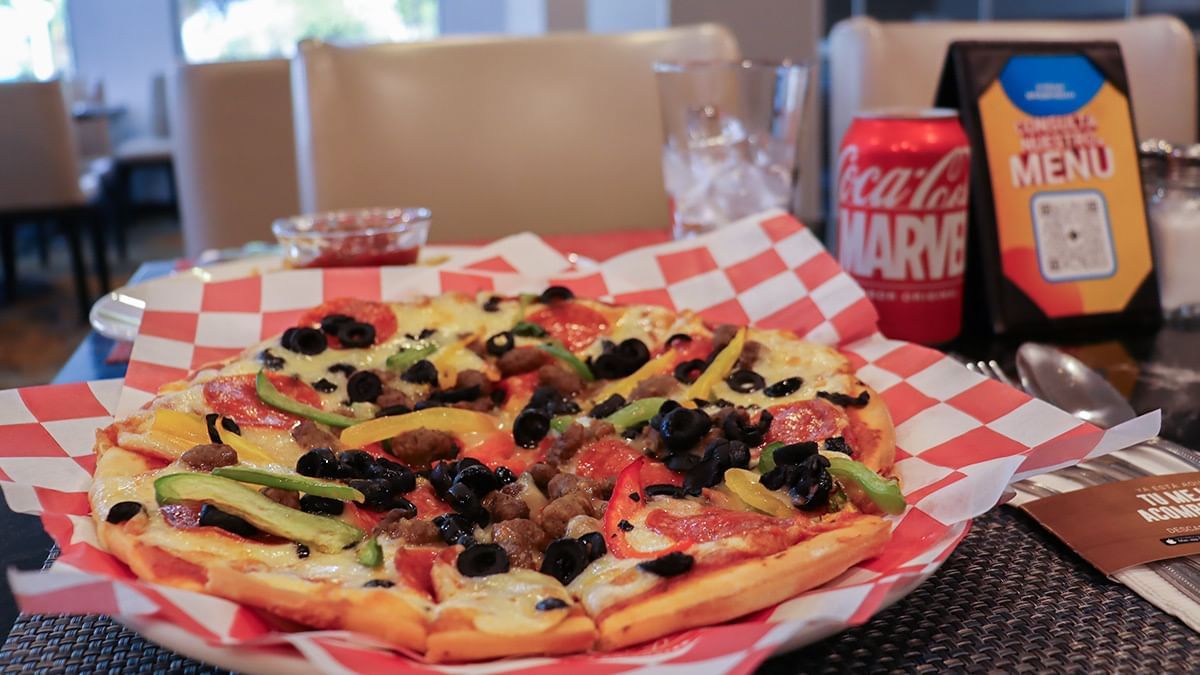 Pizza colorida con pimientos, aceitunas y carne en canasta a cuadros en Fonda De Hermosillo, Araiza Hermosillo 