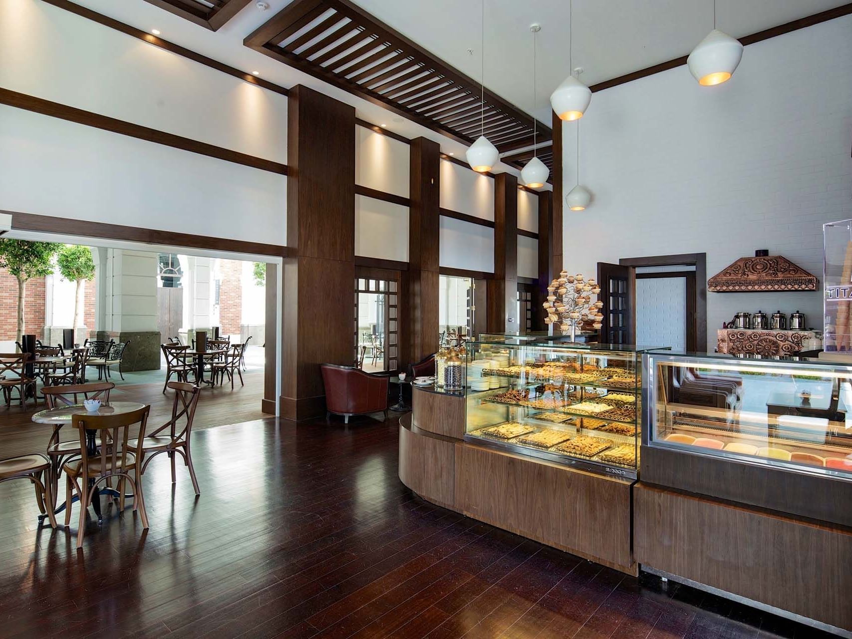 Display case of pastries and dining tables in Caprice Patisserie Bar at Titanic Deluxe Golf Belek