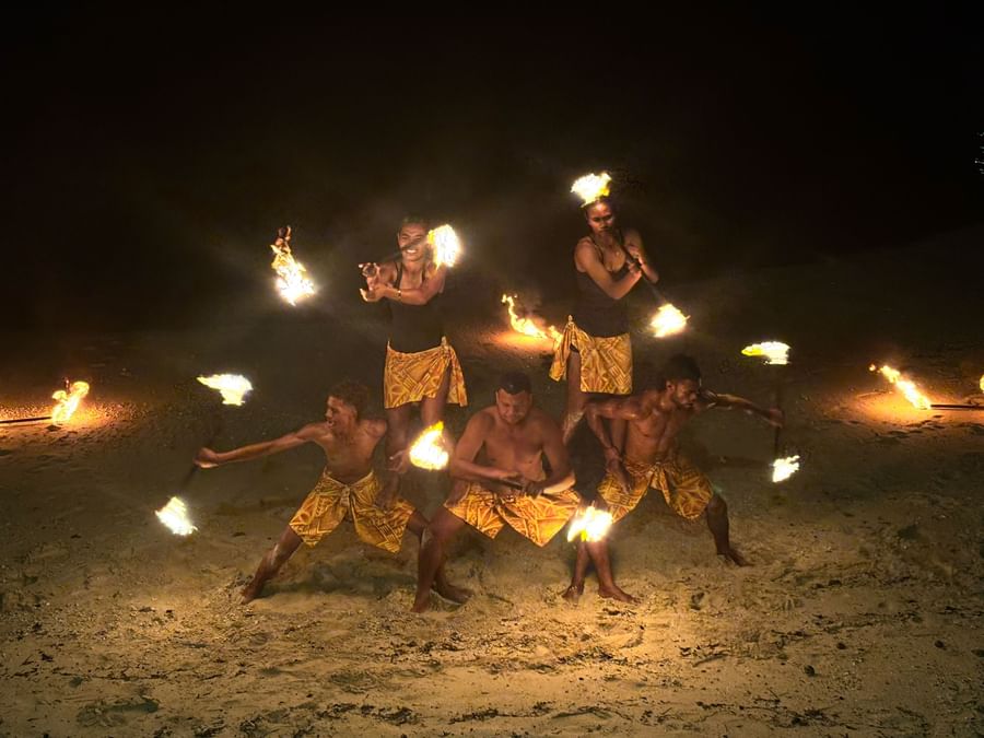 Performers at Warwick Fiji Resort and Spa engaging in a night fire dance on the beach.