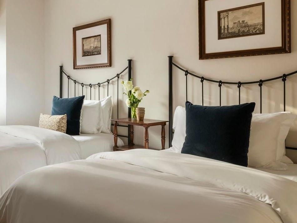 Two beds with a side table by the window in a 2 Full Beds Pool View Balcony Suite at Granduca Houston