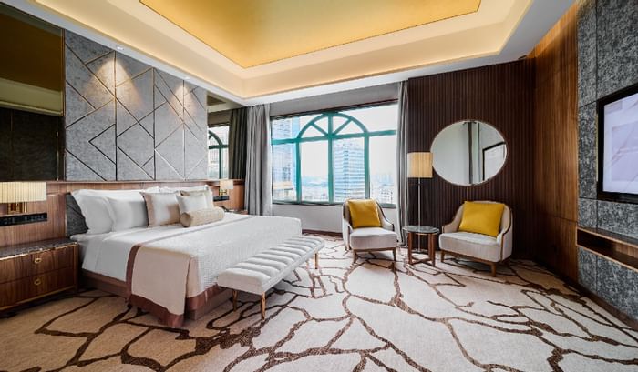 King bed, chairs & a mirror in Premier Suite at Sunway Resort