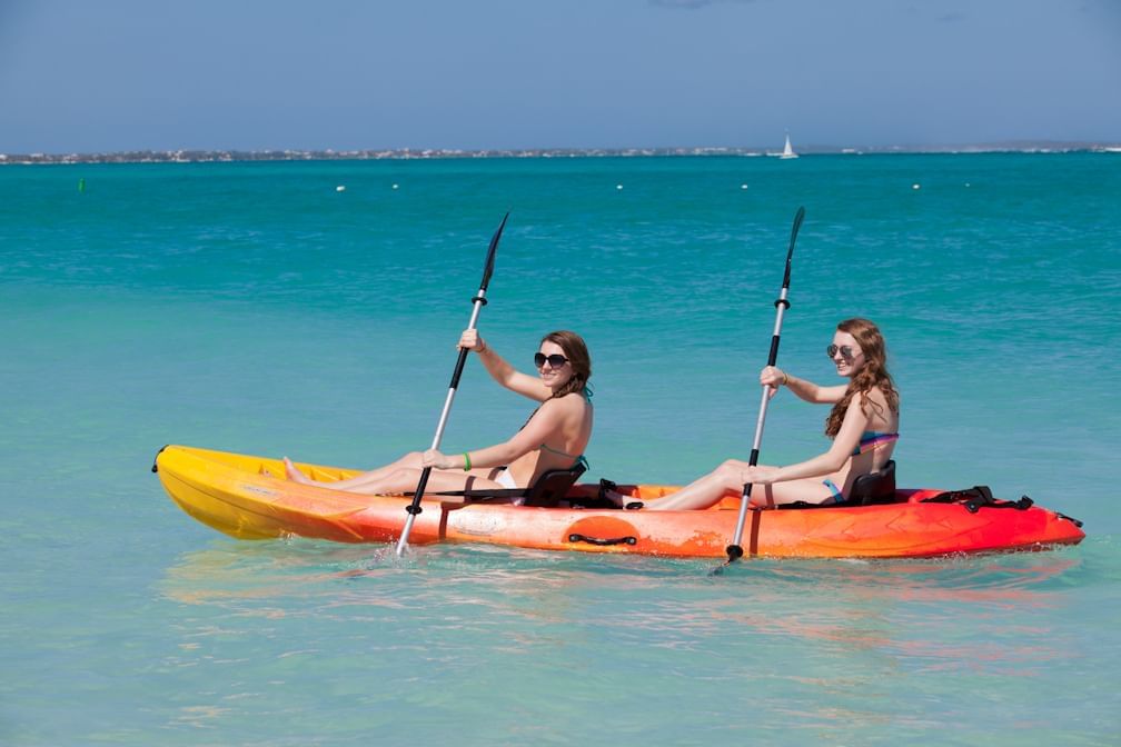 Girls kayaking on the sea near The Somerset on Grace Bay