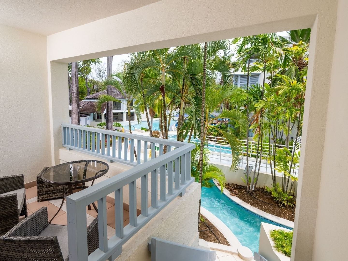Balcony with pool view and patio furniture at Savannah Beach Hotel.