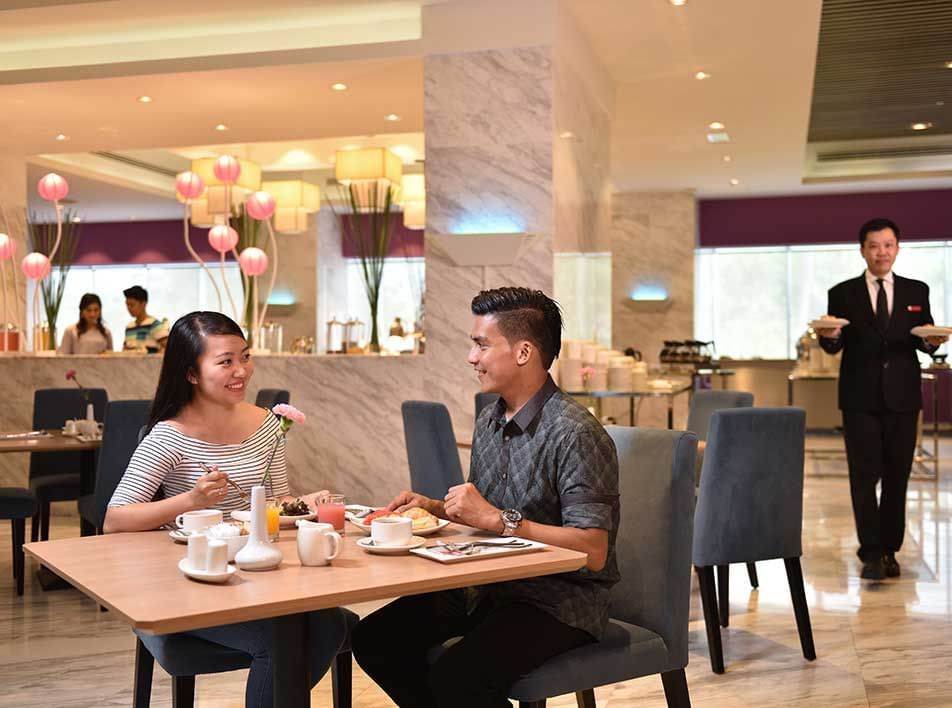 couple enjoying lunch in an elegant hotel dining room with gourmet dishes