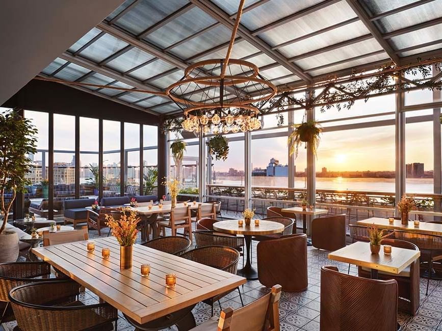 Gansevoort Rooftop during sunset time with lounge chairs, seating and hanging plants