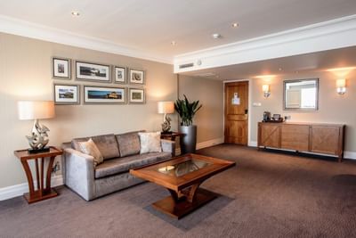 Suite Lounge area at The Aberdeen Altens Hotel with a plush grey sofa and a collection of framed wall art