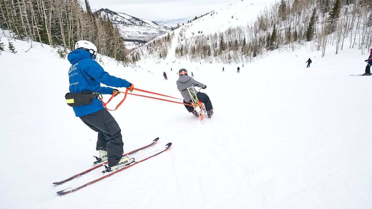 People of National Ability Center skiing downhill near Chateaux Deer Valley