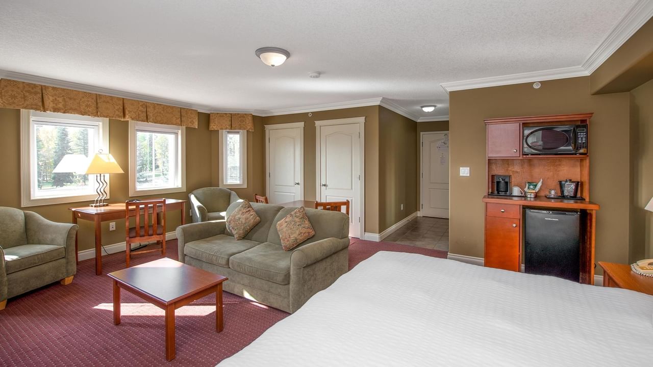 Spacious hotel suite with seating area, kitchenette, and natural light at Coast Edson Hotel