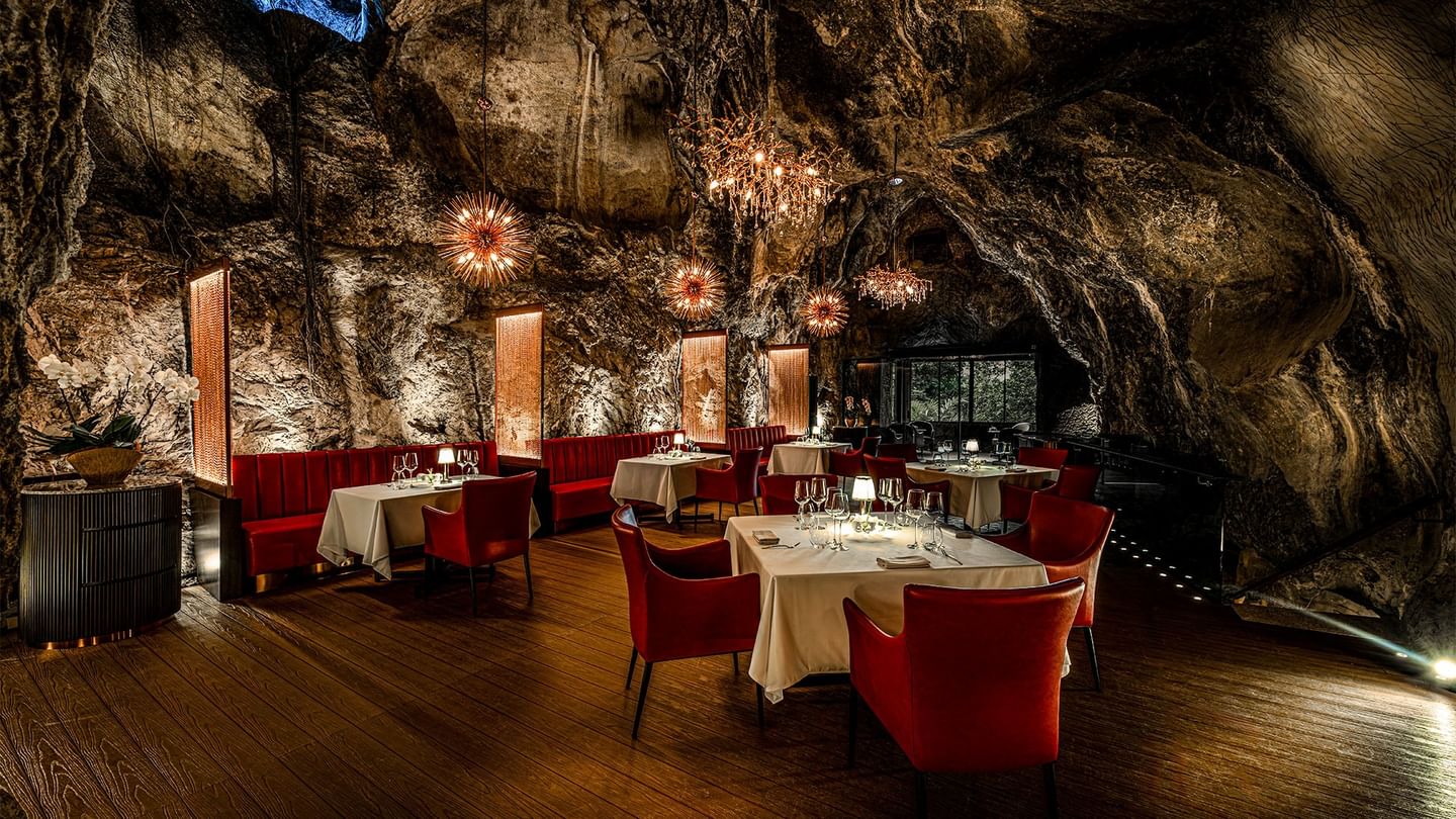Jeff's Cellar cave dining area with red chairs and set tables in Ipoh at The Banjaran Hotsprings Retreat.